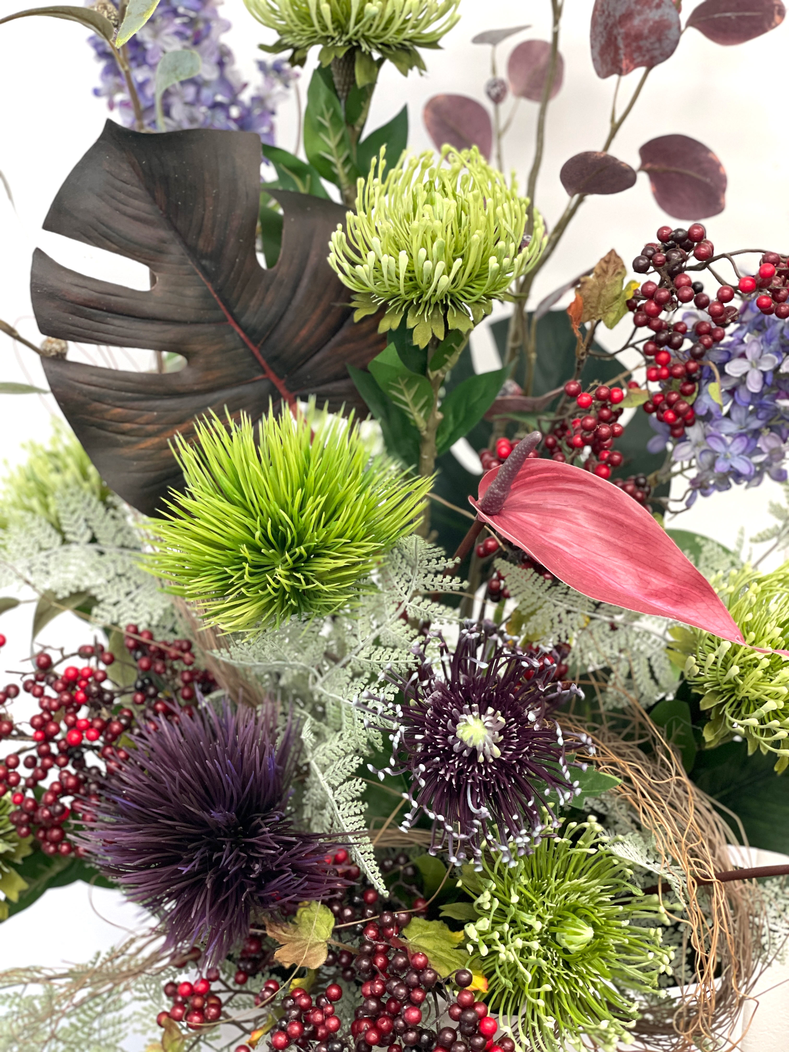 モンステラや実物を使った和調の造花アレンジメント クローズアップ タナカヤ花店